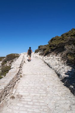 Corsica, 05/09/2017: Uluslararası Bouches de Bonifacio deniz parkı taş patika üzerinde yürüyen bir adam, tabiatı kurulan üst kısmında Bonifacio Boğazı beyaz kireç 1993 yılında