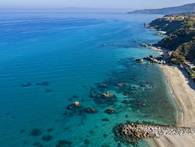 Tropea sahilinin hava manzarası, kristal berrak su ve sahilde ortaya çıkan kayalar. Calabria, İtalya