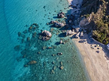 Tropea sahilinin hava manzarası, kristal berrak su ve sahilde ortaya çıkan kayalar. Calabria, İtalya