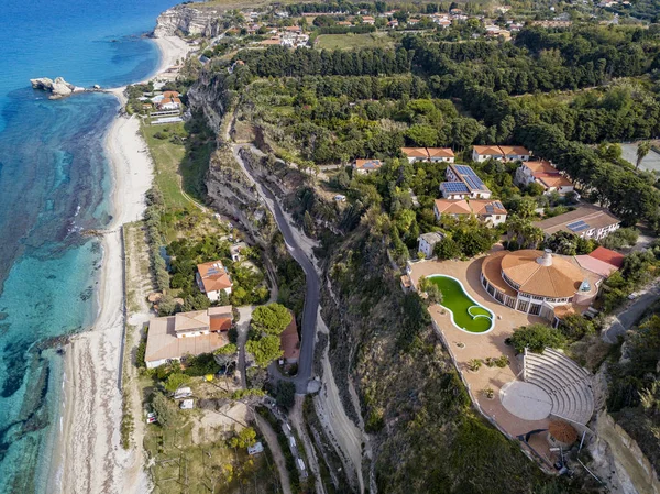 Aerial view of the Calabrian coast, villas and resorts on the cliff. Transparent sea and wild coast. Locality of Riaci near Tropea, Calabria. Italy