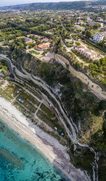 Aerial view of the Calabrian coast, villas and resorts on the cliff. Transparent sea and wild coast. Locality of Riaci near Tropea, Calabria. Italy