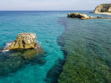 Riaci kayalıklarının havadan görünüşü, Riaci plajı Tropea, Calabria yakınlarında. İtalya. Plajlar ve kristal berrak deniz. Yüzen ve şnorkelle yüzen bir tekne ve yüzücüler.