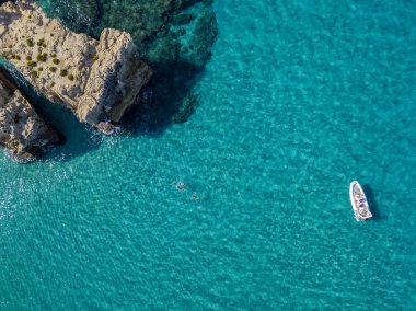 Riaci kayalıklarının havadan görünüşü, Riaci plajı Tropea, Calabria yakınlarında. İtalya. Plajlar ve kristal berrak deniz. Yüzen ve şnorkelle yüzen bir tekne ve yüzücüler.
