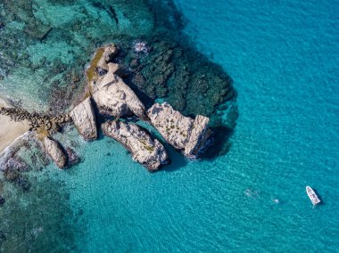 Riaci kayalıklarının havadan görünüşü, Riaci plajı Tropea, Calabria yakınlarında. İtalya. Plajlar ve kristal berrak deniz. Yüzen ve şnorkelle yüzen bir tekne ve yüzücüler.
