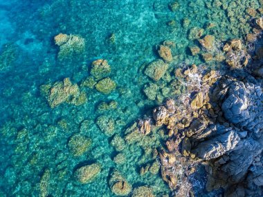 Tropea sahilinin hava manzarası, kristal berrak su ve sahilde ortaya çıkan kayalar. Calabria, İtalya. Yüzücüler, yüzenler. Calabria kıyıları.