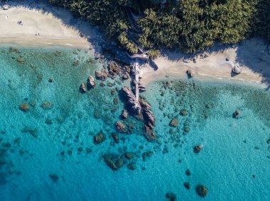 Tropea sahilinin hava manzarası, kristal berrak su ve sahilde ortaya çıkan kayalar. Calabria, İtalya. Yüzücüler, yüzenler. Calabria kıyıları.