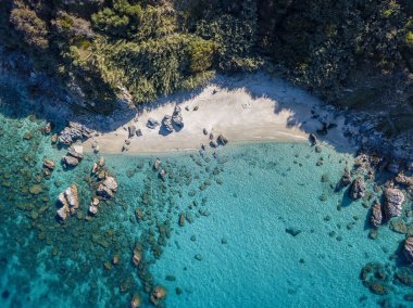 Tropea sahilinin hava manzarası, kristal berrak su ve sahilde ortaya çıkan kayalar. Calabria, İtalya. Yüzücüler, yüzenler. Calabria kıyıları.