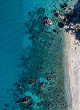 Tropea sahilinin hava manzarası, kristal berrak su ve sahilde ortaya çıkan kayalar. Calabria, İtalya. Yüzücüler, yüzenler. Calabria kıyıları.
