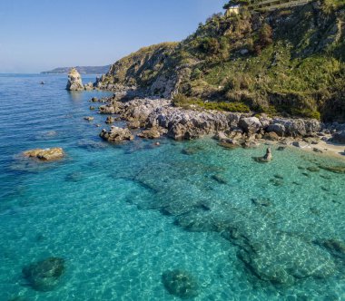 Tropea sahilinin hava manzarası, kristal berrak su ve sahilde ortaya çıkan kayalar. Rock Pizzuta. Calabria, İtalya