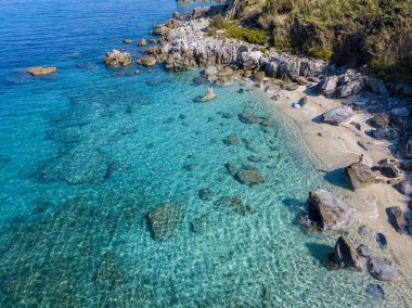 Tropea sahilinin hava manzarası, kristal berrak su ve sahilde ortaya çıkan kayalar. Calabria, İtalya. Yüzücüler, yüzenler. Calabria kıyıları.