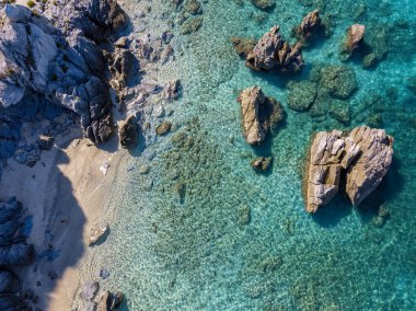 Tropea sahilinin hava manzarası, kristal berrak su ve sahilde ortaya çıkan kayalar. Calabria, İtalya. Yüzücüler, yüzenler. Calabria kıyıları.