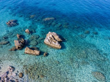 Tropea sahilinin hava manzarası, kristal berrak su ve sahilde ortaya çıkan kayalar. Calabria, İtalya. Yüzücüler, yüzenler. Calabria kıyıları.
