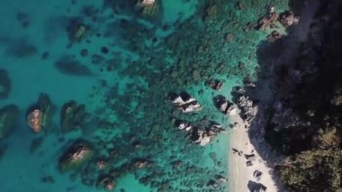 Tropea sahilinin hava manzarası, kristal berrak su ve sahilde ortaya çıkan kayalar. Calabria, İtalya. Yüzücüler, suda yüzen banyocular. Tyrhenian Denizi. Calabria kıyıları