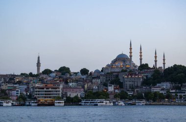 İstanbul, Türkiye, Ortadoğu: Altın Boynuz 'daki tekneler ve aydınlatılmış Süleyman Camii, Görkemli Süleyman tarafından yaptırılan Osmanlı İmparatorluk Camii manzaralı gün batımı silueti 