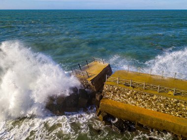 Denizde kaya ve kayalarla dolu bir rıhtımın havadan görünüşü. Pizzo Calabro iskelesi, yukarıdan panoramik manzara. Kırık iskele, denizin gücü. Dalgaların Gücü. Doğal felaketler, iklim değişikliği. Calabrian kıyıları, Güney İtalya. Calabria