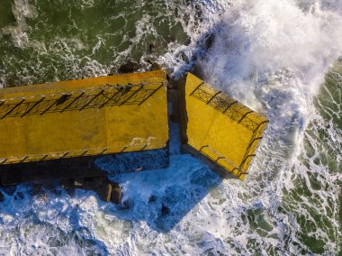 Denizde kaya ve kayalarla dolu bir rıhtımın havadan görünüşü. Pizzo Calabro iskelesi, yukarıdan panoramik manzara. Kırık iskele, denizin gücü. Dalgaların Gücü. Doğal felaketler, iklim değişikliği. Calabrian kıyıları, Güney İtalya. Calabria