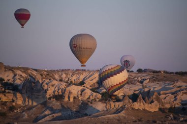 Kapadokya, Türkiye, Avrupa, 07 / 08 / 2019: Şafakta yüzen sıcak hava balonları ve Orta Anadolu 'nun tarihi bölgesinin tarihi bölgesi Cavusin çevresindeki olağanüstü doğal güzelliklere sahip vadi manzarası