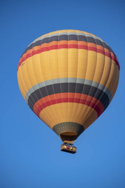 Kapadokya, Türkiye, Avrupa, 07 / 08 / 2019: Orta Anadolu 'nun tarihi bölgesindeki Cavusin vadisi üzerinde şafaktan sonra gökyüzünde yüzen geleneksel bir sıcak hava balonu