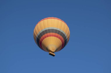 Kapadokya, Türkiye, Avrupa, 07 / 08 / 2019: Orta Anadolu 'nun tarihi bölgesindeki Cavusin vadisi üzerinde şafaktan sonra gökyüzünde yüzen geleneksel bir sıcak hava balonu