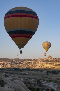 Kapadokya, Türkiye, Avrupa, 07 / 08 / 2019: Orta Anadolu 'nun tarihi bölgesinin tarihi ve ünlü kenti Uchisar' ın hava manzarası, olağanüstü doğal güzelliklere sahip, şafaktan sonra gökyüzünde yüzen geleneksel sıcak hava balonları ile birlikte 
