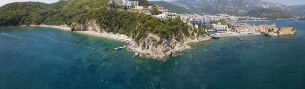 Aerial view of Mogren beach (two sandy beaches) and the old city (stari grad) of Budva, Montenegro. Jagged coast on the Adriatic Sea