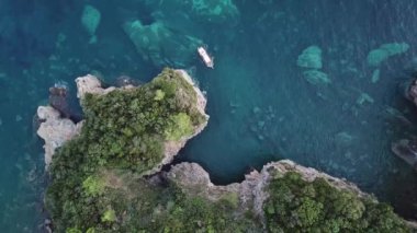Mogren sahilleri arasında Mogren 'e yakın bir teknenin hava görüntüsü. Budva. Karadağ. Şeffaf denize bakan sarp kayalıkları olan sivri kıyılar. Vahşi doğa ve Akdeniz maketi