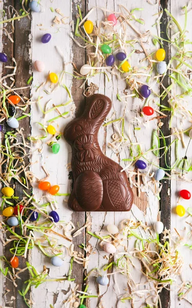 Пасха: Шоколадный пасхальный кролик в окружении конфеты — стоковое фото