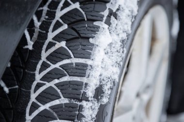 Kaygan bir yolda karla kaplı arabanın lastiğini kapat.