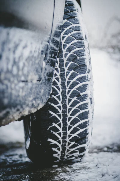Αυτοκίνητο ελαστικών το χειμώνα στο δρόμο που καλύπτεται με χιόνι, κλείστε pictu — Φωτογραφία Αρχείου