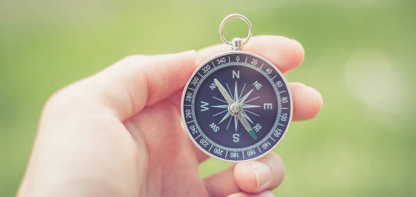 Винтажный компас в руке, концепция приключений и открытий
  