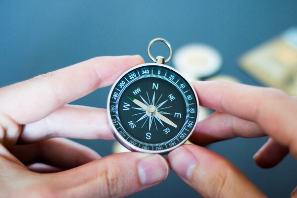 Closeup of a mans hand holding a compass in his hand. Concept for business, innovation