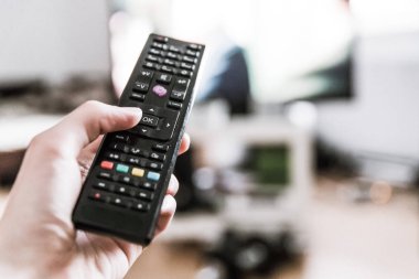 TV uzaktan denetim ön planda, bulanık arka planda tv.