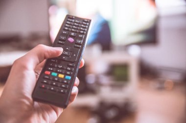 TV uzaktan denetim ön planda, bulanık arka planda tv.