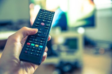 TV uzaktan denetim ön planda, bulanık arka planda tv.