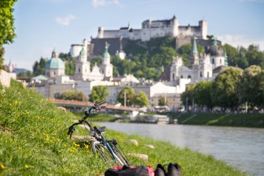 Yaz mevsiminde Salzburg 'un panoramik şehir manzarası, ön planda bisiklet.