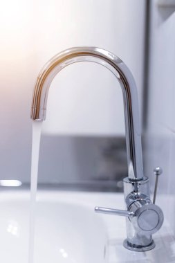 Temiz bir banyodaki musluğu kapat. Su tasarrufu, güneş ışığı. 