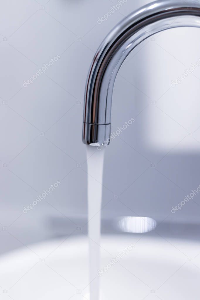 Close up of a water spigot in a clean bathroom. Water saving.