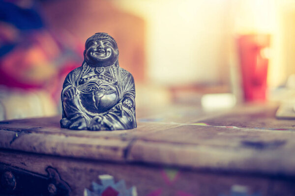 Feng shui: Buddha statue at on a table in the own living room. 