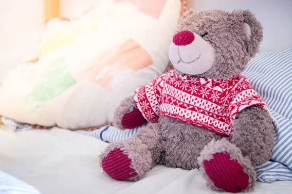 Cute teddy bear toy is sitting in the bed, wakeup at morning