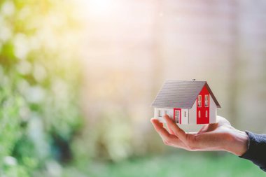 Yeni ev ve ev kavramı: Kırmızı ev modeli erkek elinde, boşluğu kopyala