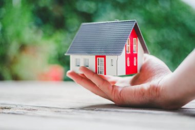 Yeni ev ve ev konsepti: Kırmızı ev modeli erkek elinde