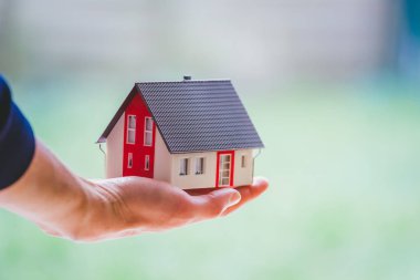 Yeni ev ve ev konsepti: Kırmızı ev modeli erkek elinde