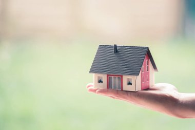 Yeni ev ve ev konsepti: Kırmızı ev modeli erkek elinde