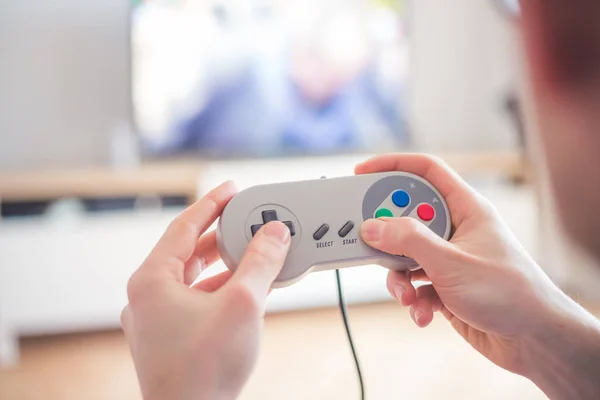 Boy is playing video games with a retro computer gaming in the living room