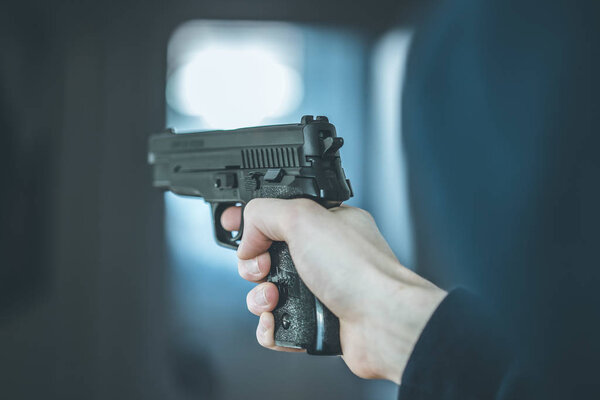 Man is holding a black fire weapon, closeup