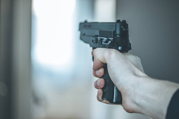 Man is holding a black fire weapon, closeup