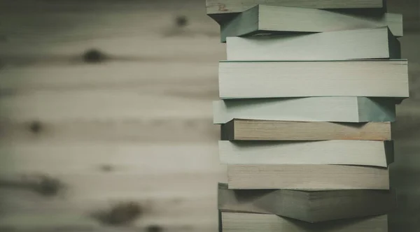 Stack of books on wooden background, knowledge and science