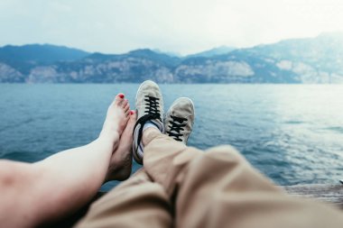 Spor ayakkabılı bir adam ve çıplak ayaklı bir kız tatil akşamının tadını çıkarıyorlar.