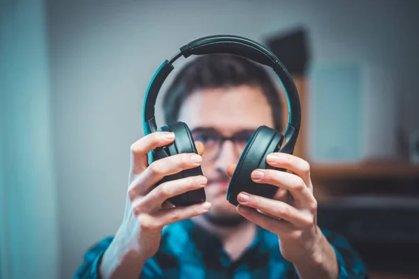 Joven Caucásico Hombre Está Sosteniendo Auriculares Negros Con Ganas Escuchar — Foto de Stock