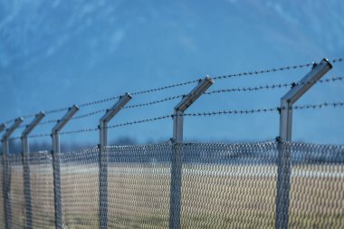 Military fence, demarcate the border, closeup, blurry background